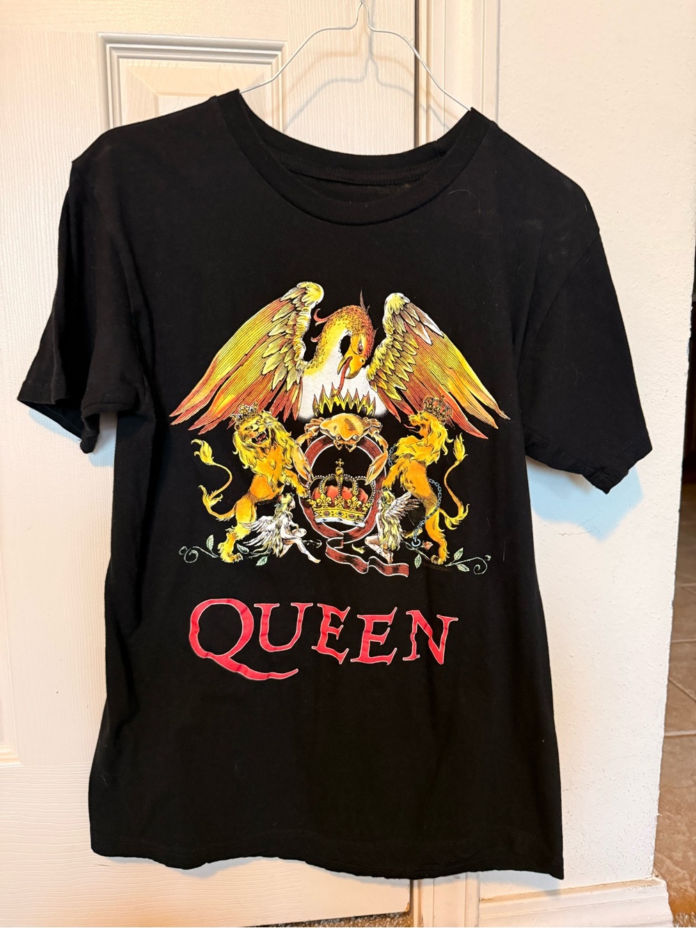 Que Black Graphic Band T-Shirt with Yellow and Red Crest